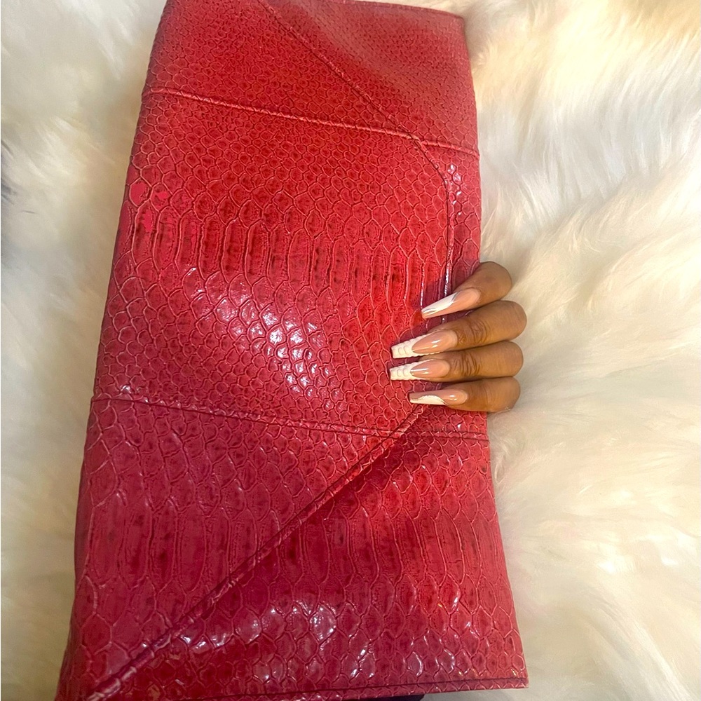 Dark pink/reddish envelope clutch.